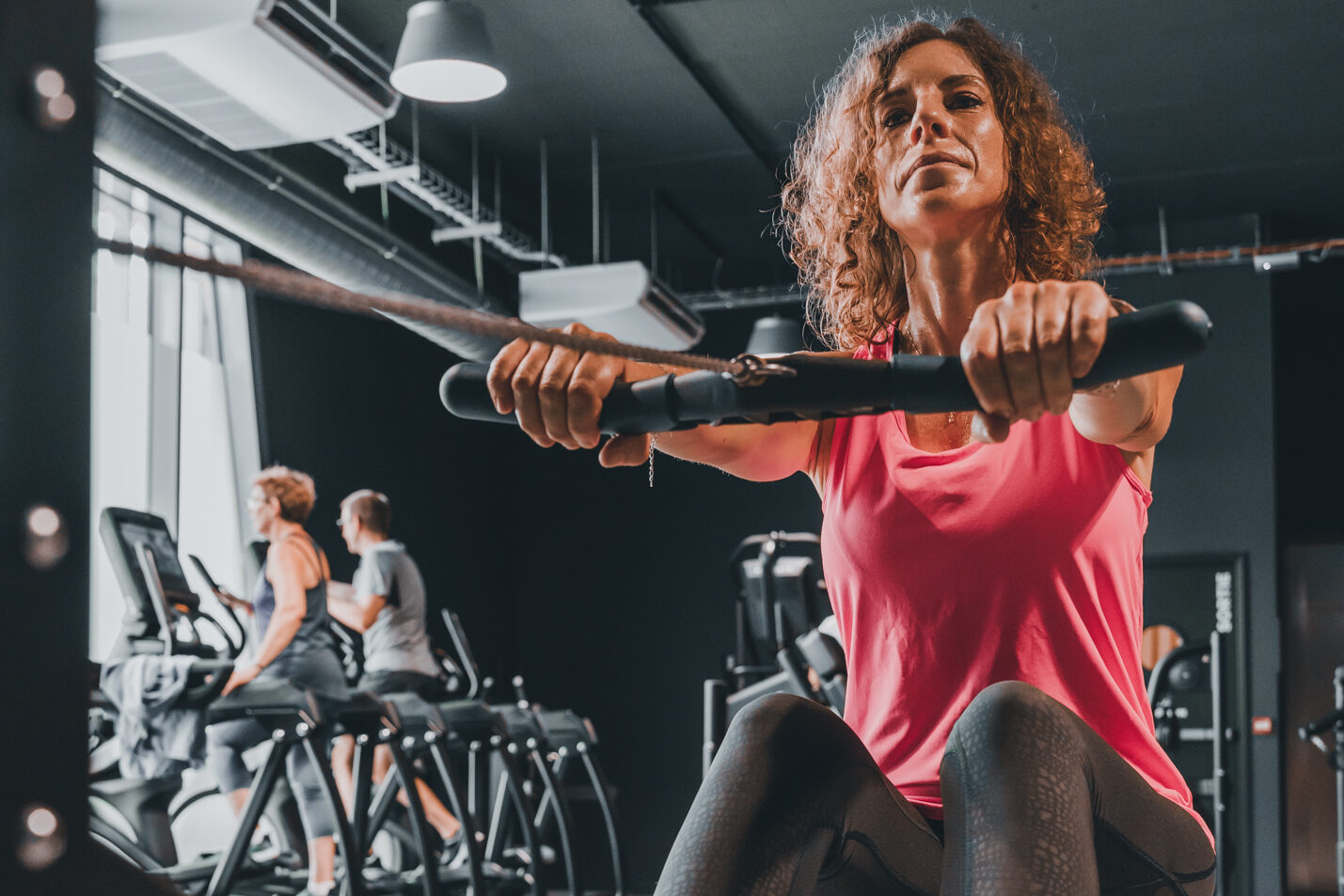 Femme effectuant des étirements de TRX suspension training à l'Academie du Mouvement à Saint-Maur-des-Fosses.